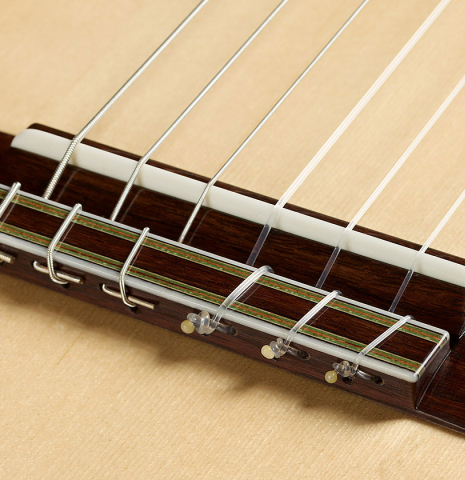 The bridge, tie-block and saddle of a 2025 Manuel Arango "Negra" flamenco guitar made of spruce and Indian rosewood