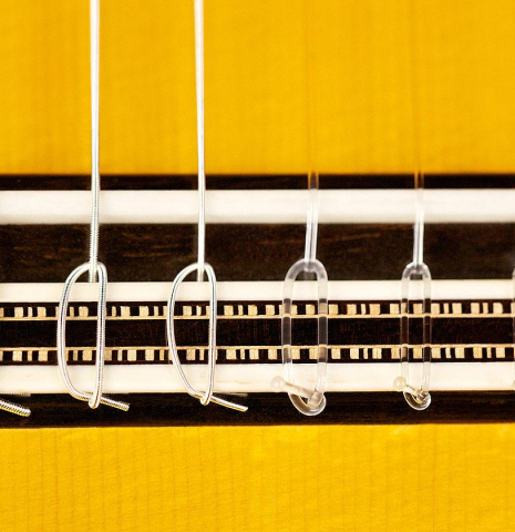 The bridge and tie block of a 2015 Francisco Barba flamenco guitar made with spruce and cypress