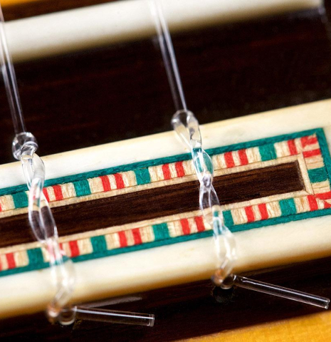 The bridge, tie-block and saddle of a 2007 Francisco Barba flamenco guitar made of spruce and cypress