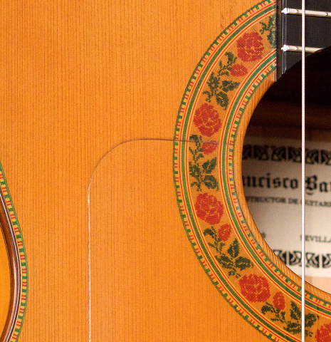 The soundboard and rosette of a 2007 Francisco Barba flamenco guitar made with cedar and cypress