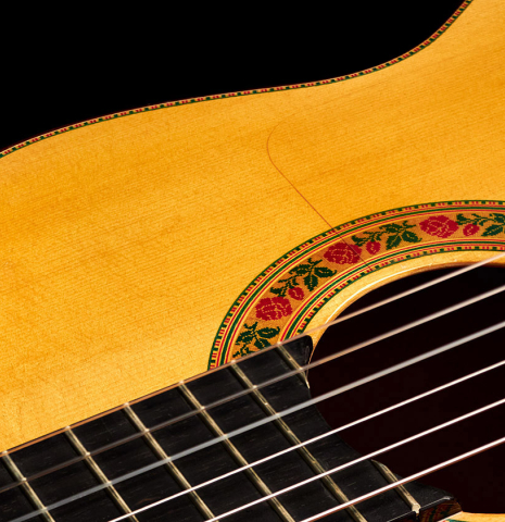 The soundboard and rosette of a 2015 Francisco Barba flamenco blanca guitar made of spruce and cypress.