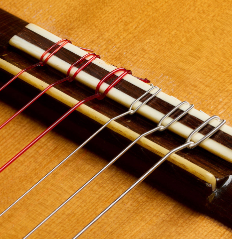 The bridge, tie-block and saddle of a 1952 Marcelo Barbero flamenco blanca guitar w/pegs made of spruce and cypress