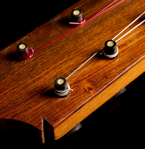 The headstock and traditional wooden tuning pegs of a 1952 Marcelo Barbero flamenco blanca guitar w/pegs made of spruce and cypress