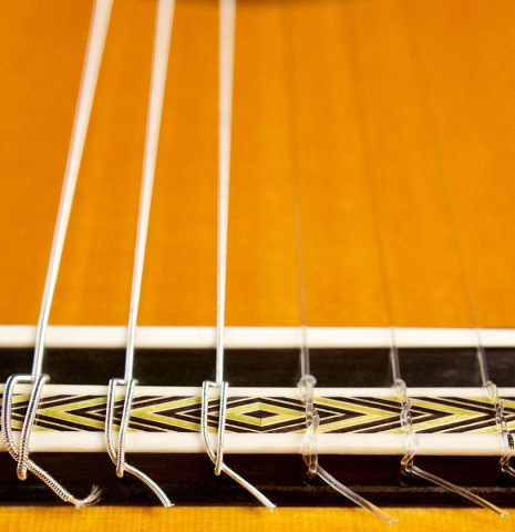 The bridge, tie-block and saddle of a 2004 Paulino Bernabe "Flamenco Negra" flamenco guitar made of spruce and CSA rosewood