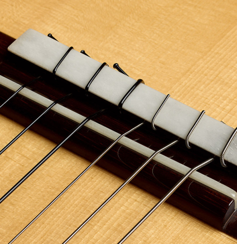 The bridge, tie-block and saddle of a 2026 Jakob Biehler "Flamenca Blanca" with pegs made of spruce and cypress