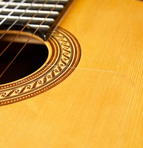 The soundboard and rosette of a 1996 Tobias Braun flamenco blanca guitar made of spruce and cypress