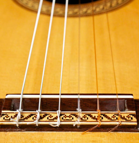 The bridge and soundboard of a 1996 Tobias Braun flamenco blanca guitar made of spruce and cypress