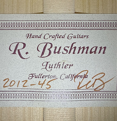 The label of a 2012 Ron Bushman w/pegs flamenco guitar made of spruce and cypress