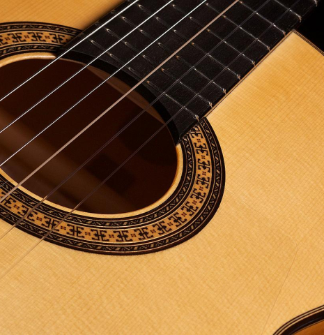 The rosette and nylon strings of a 2022 Hermanos Camps &quot;Primera Blanca&quot; flamenco guitar made of spruce and cypress