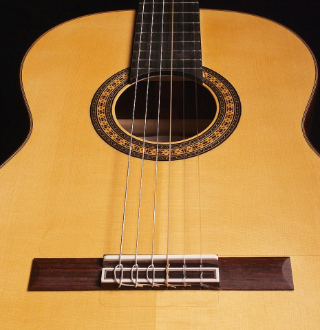 The soundboard and bridge of a 2022 Hermanos Camps &quot;Primera Negra&quot; flamenco guitar made of spruce and Indian rosewood