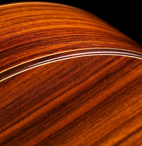 The side and binding of a 2022 Hermanos Camps &quot;Primera Negra&quot; flamenco guitar made of spruce and Indian rosewood
