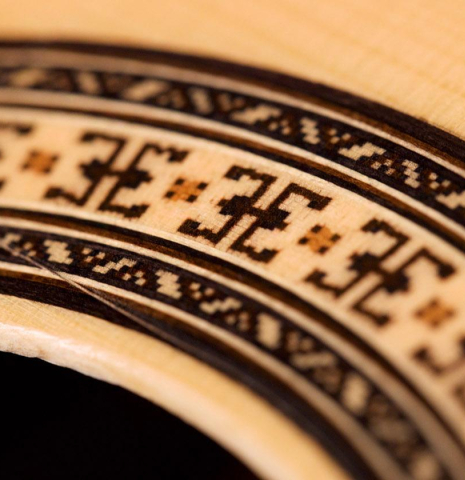 A close-up of the rosette of a Hermanos Camps &quot;FL11C Negra&quot; flamenco guitar made of spruce and Indian rosewood