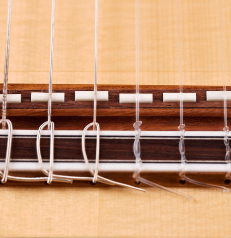 The bridge of a Hermanos Camps &quot;FL11C Negra&quot; flamenco guitar made of spruce and Indian rosewood