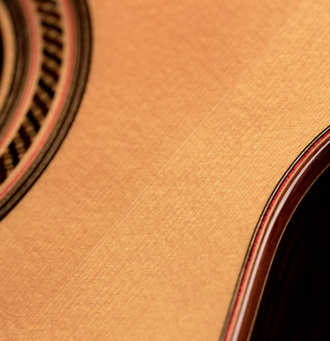 The soundboard and rosette of a 2015 Hermanos Camps "Primera Negra" flamenco guitar made of spruce and Indian rosewood