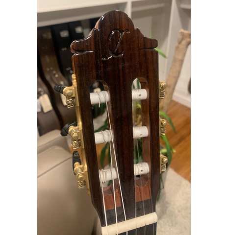 The "C" embossed headstock of a Hermanos Camps "Primera Blanca" flamenco guitar made of spruce and cypress