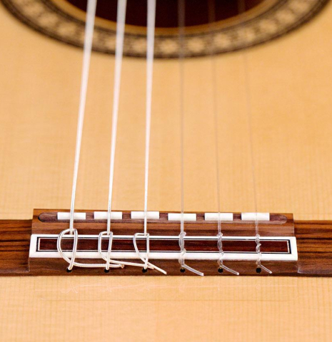 The bridge and broken saddle of a Hermanos Camps &quot;FL11C Blanca&quot; flamenco guitar made of spruce and cypress