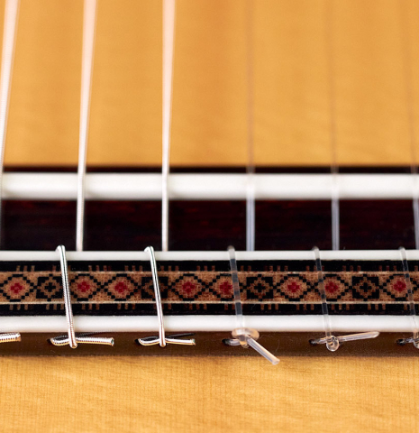 The bridge and saddle of a 2022 Vicente Carrillo "1aF Negra" made with spruce top and African rosewood back and sides