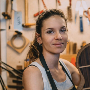 María Conde in a guitar workshop holding the back of a guitar in progress