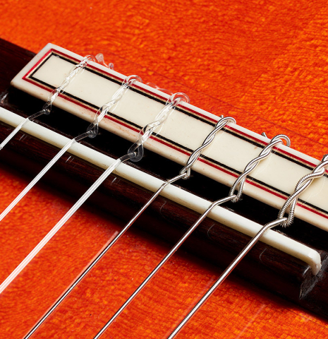 The bridge, tie-block and saddle of a 2024 Felipe Conde "A 26 Especial" flamenco guitar made of spruce and cypress