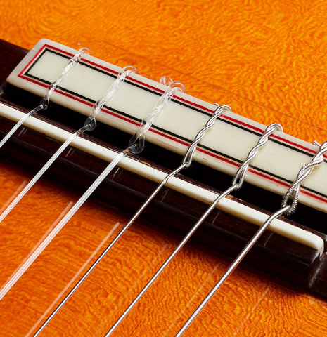 The bridge, tie-block and saddle of a 2024 Felipe Conde "FC 28 Especial" flamenco negra guitar made of spruce and CSA rosewood