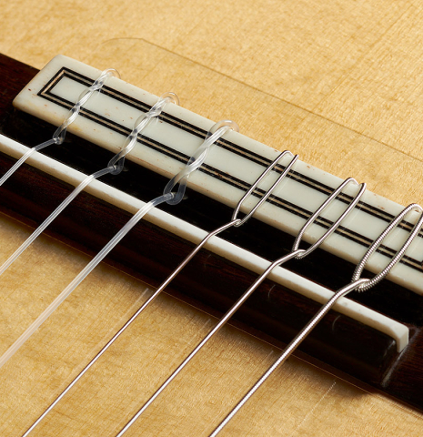The bridge, tie-block and saddle of a 2023 Felipe Conde Crespo "Negra" flamenco guitar made of spruce and African rosewood