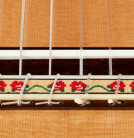 The bridge, tie-block and saddle of a 2024 Andy Culpepper w/pegs flamenco guitar made of cedar and cypress
