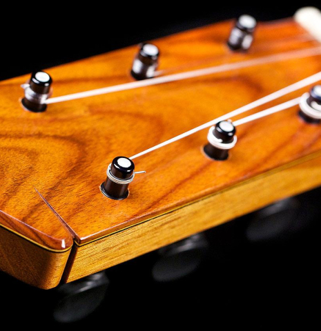 The headstock and mechanical pegs of a 2017 Ethan Deutsch flamenco guitar with pegs made with spruce and cypress