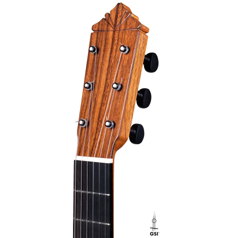 The headstock of a 2018 Gerundino Fernandez Hijo cedar/cypress "Blanca" flamenco guitar with pegs on a white background