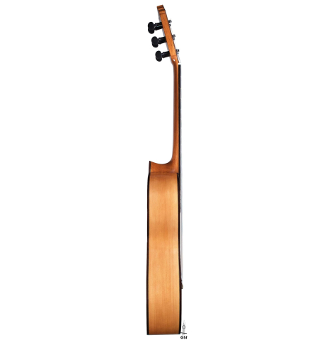 The side of a 2018 Gerundino Fernandez Hijo cedar/cypress "Blanca" flamenco guitar with pegs on a white background