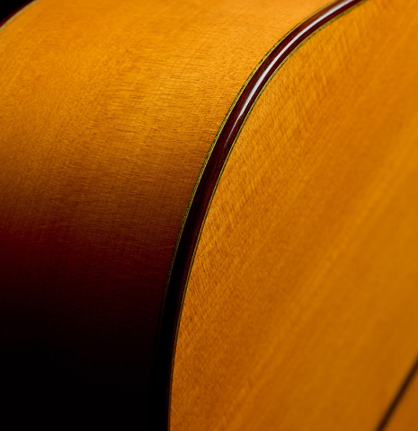 The top binding and purfling of a 1999 Gerundino Fernandez w/pegs flamenco guitar made of spruce and cypress