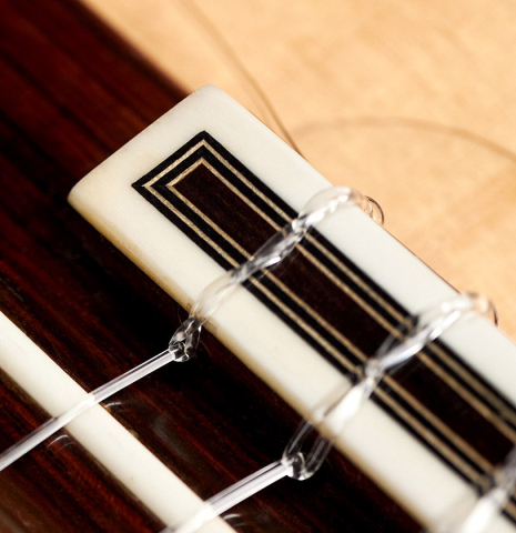 The tie block of a 1989 Arcangel Fernandez flamenco guitar w/pegs made with spruce and cypress.