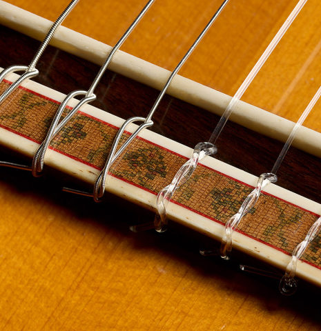 The bridge, tie-block and saddle of a 1975 Gerundino Fernandez "Negra" flamenco guitar made of spruce and Indian rosewood