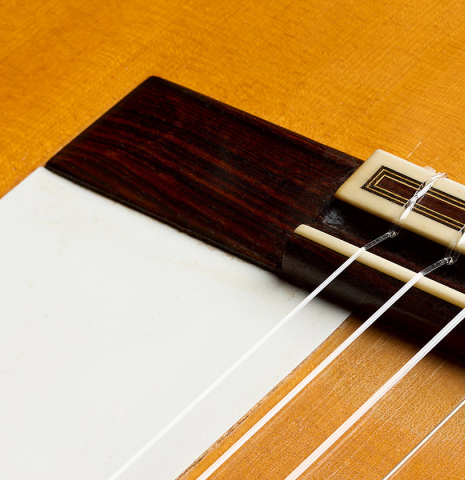 The bridge and tap plate of a 1970 Arcangel Fernandez flamenco guitar made of spruce and cypress