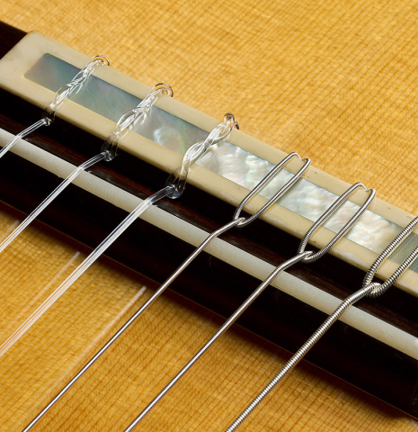 The bridge, tie-block and saddle of a 2025 Juan Fregenal flamenco guitar made of spruce and cypress