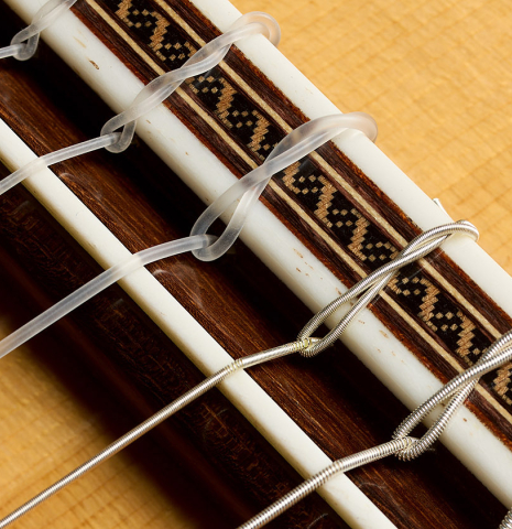 The bridge, tie-block and saddle of a 2025 Darío García flamenco guitar made of spruce and cypress
