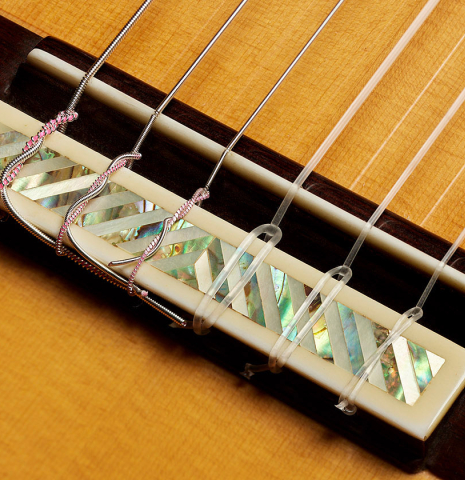 The bridge, tie-block and saddle of a 2006 Conde Hermanos "Felipe V" flamenco negra guitar made of spruce and CSA rosewood