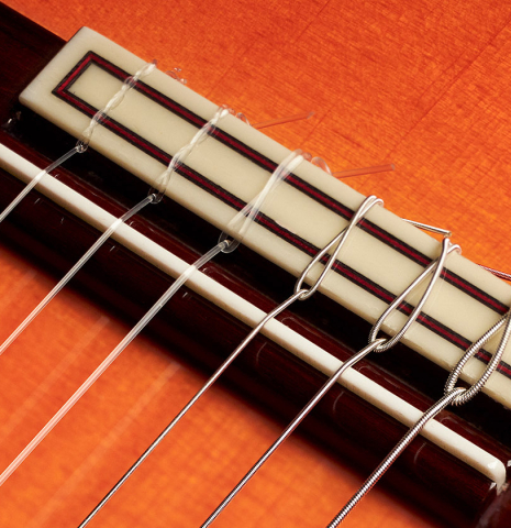 The bridge and saddle of a 2011 Felipe Conde "FC 27" flamenco guitar made with spruce and Indian rosewood