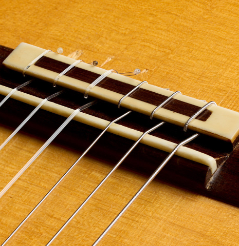 The bridge, tie-block and saddle of a 2017 Stephen Hill "2a Blanca" flamenco guitar made of spruce and cypress