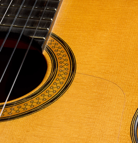 The soundboard, tap plate and rosette of a 2017 Stephen Hill "2a Blanca" flamenco guitar made of spruce and cypress