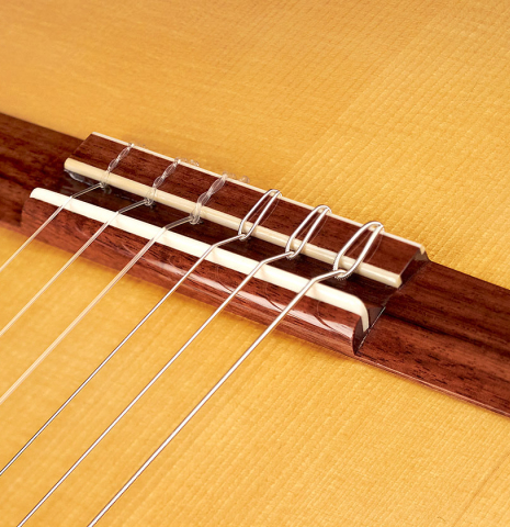 The bridge of a 2023 Wolfgang Jellinghaus "Flamenca Negra" flamenco guitar with spruce and Granadillo.