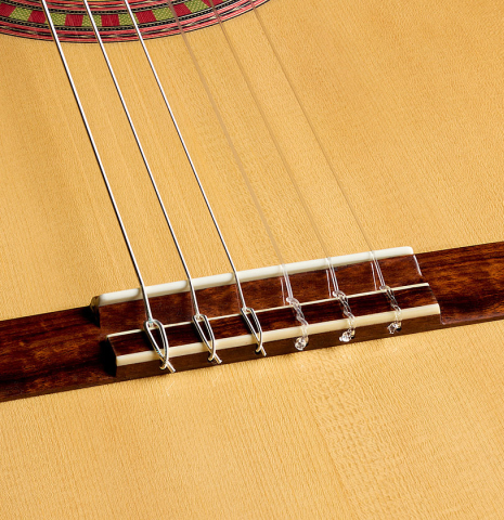 The bridge, tie-block and saddle of a 2026 Wolfgang Jellinghaus "Flamenca Negra" flamenco guitar made of spruce and granadillo