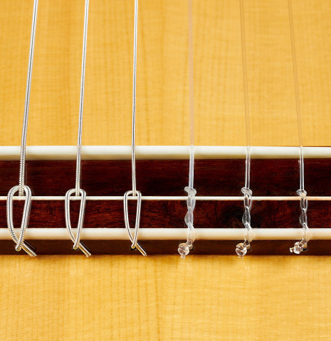 The bridge, tie-block and saddle of a 2024 Wolfgang Jellinghaus "Flamenca Negra" flamenco guitar with spruce and Indian rosewood