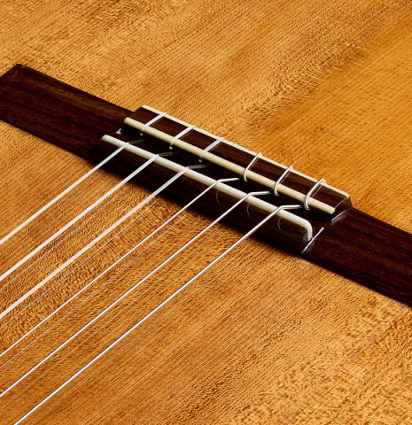 The bridge, tie-block and saddle of a La Cañada "1934 Domino Esteso - A" flamenco guitar made of spruce and cypress