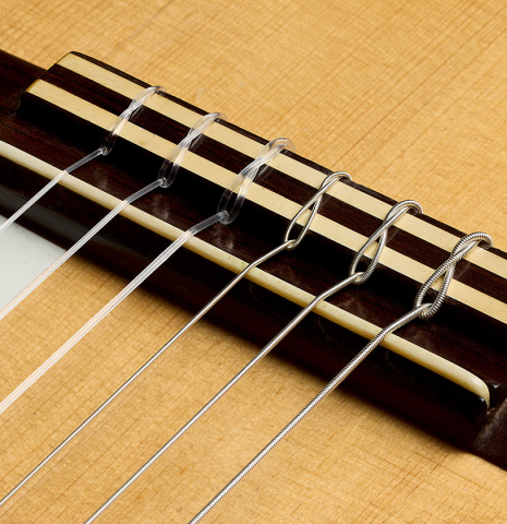 The bridge, tie-block and saddle of a 1961 Marcelino Lopez "Blanca" flamenco guitar made of spruce and cypress