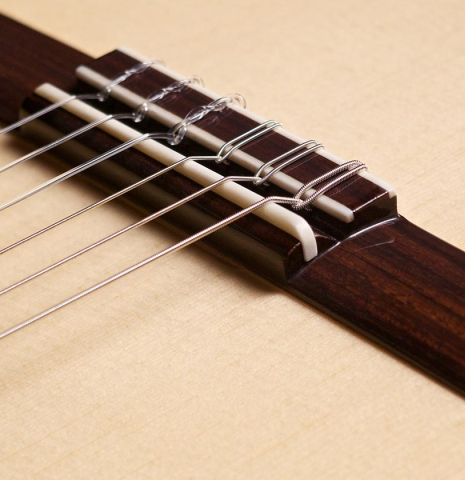 The bridge and saddle of Loriente "Carmen" flamenco guitar made with spruce top and cypress back and sides
