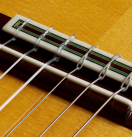 The bridge, tie-block and saddle of a 2025 Teodoro Perez "Flamenco Negra" guitar made of spruce and African rosewood