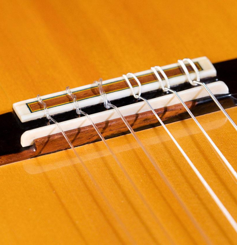 The bridge, tie-block and saddle of a 2013 Graciliano Perez "Negra" flamenco guitar (ex Fareed Haque) made of spruce and Honduran rosewood