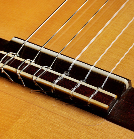 The bridge, tie-block and saddle of a 1999 Jose Marin Plazuelo flamenco guitar made of spruce and cypress