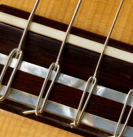 The bridge, tie-block and saddle of a 1994 Jose Marin Plazuelo flamenco guitar made of spruce and cypress