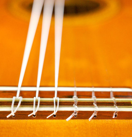 The bridge, tie-block and saddle of a 1965 Jose Ramirez "1aF AM" flamenco guitar made of cedar and cypress